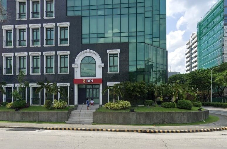 BPI Alabang Madrigal Park Branch, which occupies the ground floor of a modern, dark gray, glass-fronted office building
