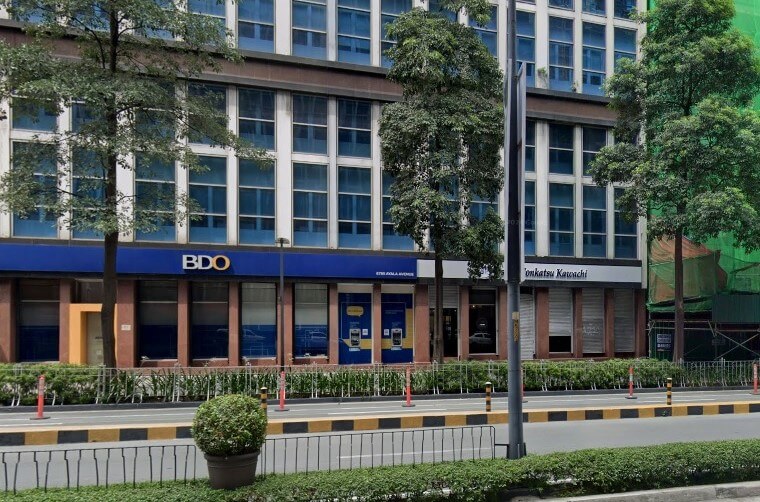 Exterior view of the BDO bank and restaurant storefronts on the ground floor of the BDO 6780 Ayala Avenue building, with a street and trees in the foreground