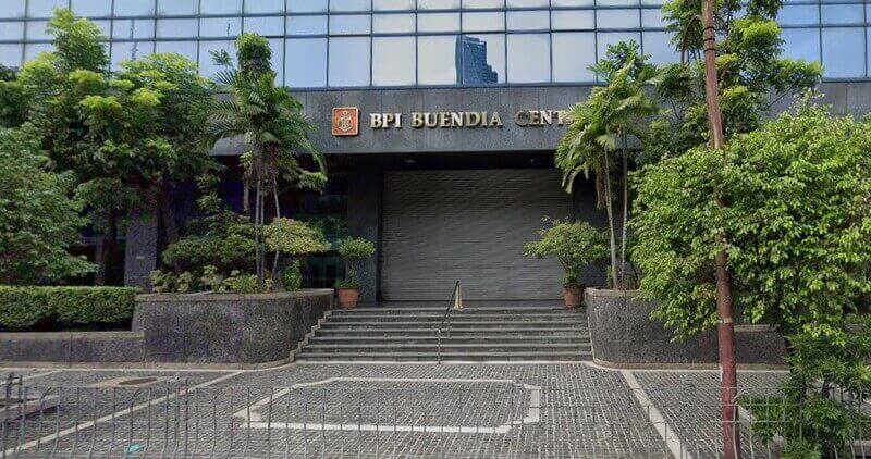Exterior view of the BPI Buendia Center building entrance, featuring the corporate signage, stone steps, and surrounding greenery
