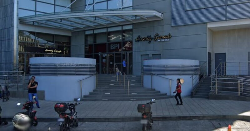 Exterior entrance of the BPI branch at Assembly Grounds at The Rise, featuring concrete steps, a glass facade, and a modern metal canopy