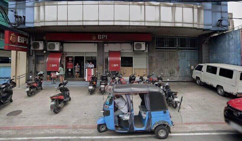 Exterior view of the BPI Pritil branch in Tondo, Manila, featuring the red bank storefront with parked motorcycles and a blue tricycle in the foreground