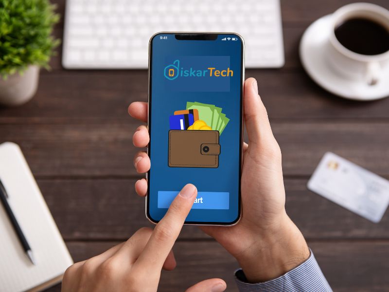 A smartphone displaying the DiskarTech mobile app interface on a blue screen. The screen displays the "DiskarTech" logo and an illustration of a digital wallet containing cash and cards.
